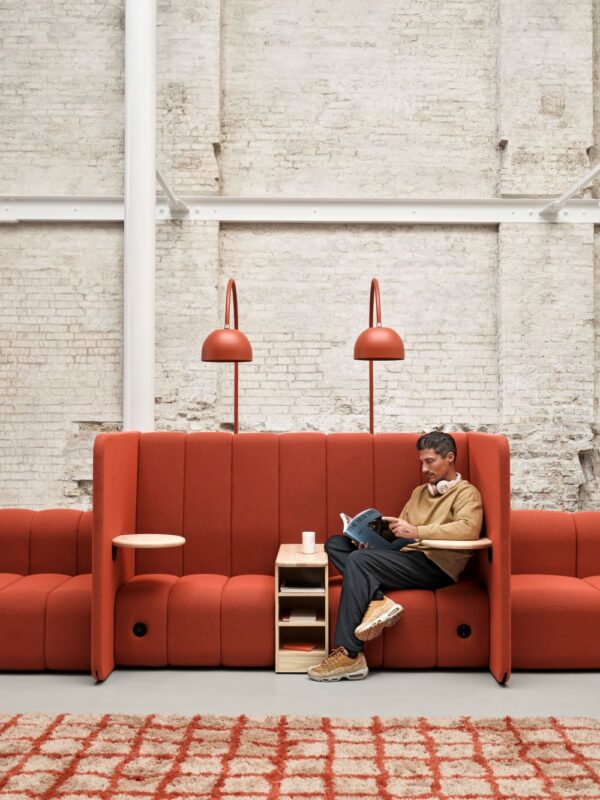Affe Acoustic BOB muokattava punainen sohva, jossa istuu henkilö lukemassa.